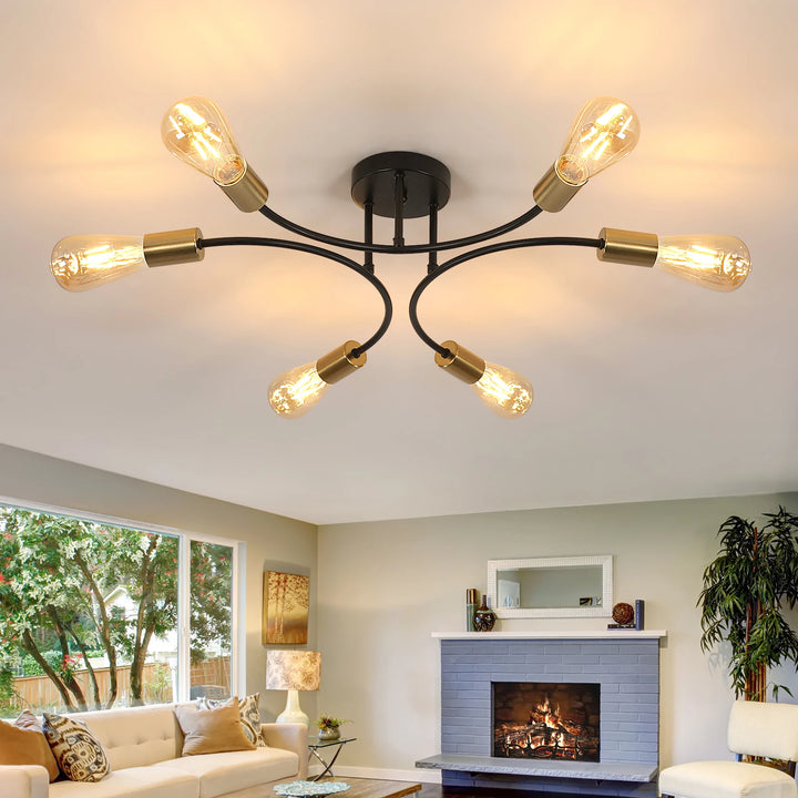 Modern black and gold chandelier illuminating a cozy living room with a fireplace and large windows.