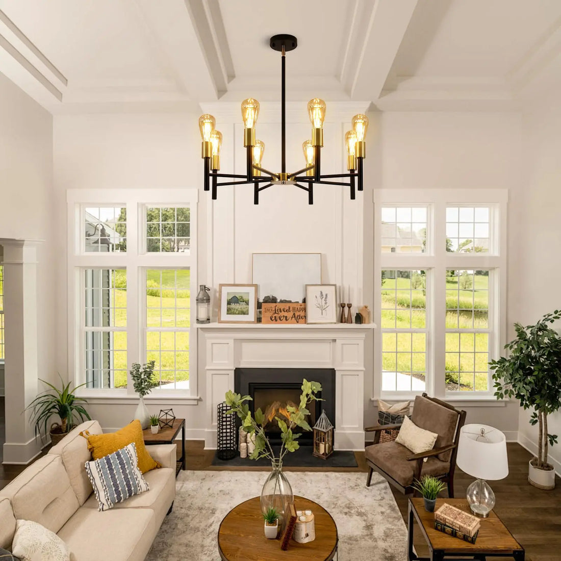 Black and gold chandelier hanging in a bright living room with a fireplace and large windows.