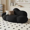 A black, cloud-shaped sofa with three rounded cushions.