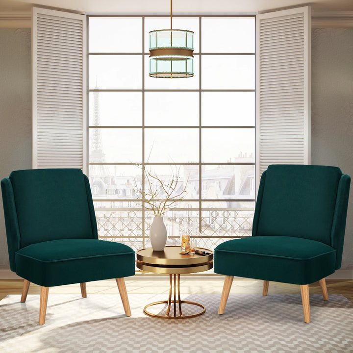 Two green accent chairs with rubber wood legs placed near a sunlit window, creating a modern and inviting living room scene.