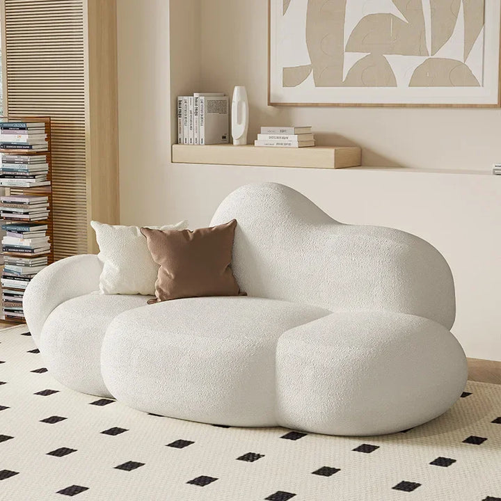 Front-angle view of a white cloud-shaped sofa with plush, rounded seats and a softly curved back, showcasing a calm, minimalist Wabi Sabi Nordic style.

